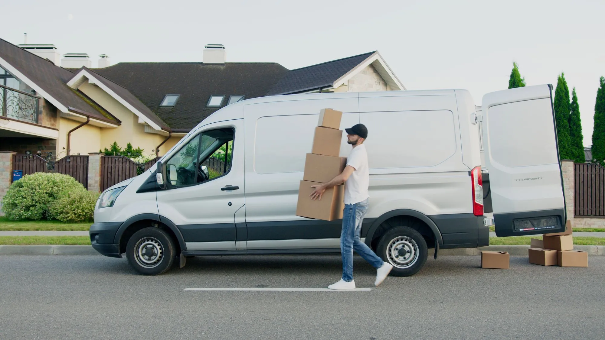 loading donation boxes into a cargo van outside a home